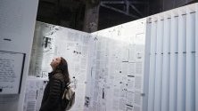 Посетител разглежда пътуващата арт инсталация &quot;Писане върху стена&quot;, съставена от есета, поеми, писма, рисунки и бележки на затворници от целия свят. Инсталацията е разположена в Хайлайн парк в Ню Йорк.