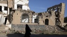 Жена минава край разрушена сграда, бомбардирана по време на водените от Саудитска арабия нападения над Сана, Йемен. Страната е във въоръжен конфликт от края на 2014 г.