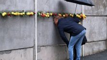 Двойка гледа през дупка в мемориал в Берлин по повод 30-тата годишнина от падането на Берлинската стена.