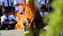 Индонезийска учителка взима участие в учение за гасене на пожар в училище в Банда Ачех.