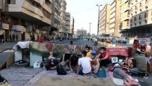 Иракски протестиращи си почиват зад барикада по време на демонстрация в Багдад срещу правителството.