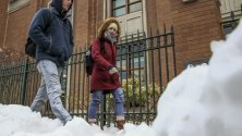 Хора в дебели дрехи в университетски кампус в Чикаго, Илинойс, САЩ. Регионът е обхванат от арктически студ.