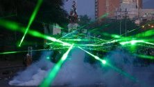 Протестиращи светят с лазерни лъчи по време на демонстрация на Плаза Италия в Сантяго, Чили. Най-малко 20 души са загиналите от избухването на протестите на 20 октомври.