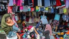 Индонезийки сортират дрехи на пазар за стоки втора ръка в Медан, Индонезия. Централната банка обяви, че се очаква инфлацията в страната да е около 3,1%.