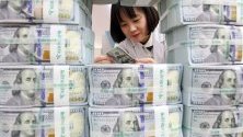 Служителка брои стодоларови банкноти в централата на банка KEB Hana в Сеул, Южна Корея. Резервите от чуждестранна валута в страната достигнаха рекорд от над 407 милиарда долара.