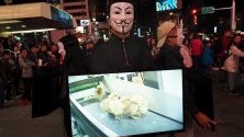 Членове на "Анонимните за Безгласните" показват видеокадри на животни, убивани в кланици, по време на протест в Тайпе, Тайван.