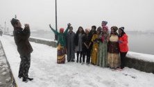 Туристи позират пред езерото Дал по време на снеговалеж в Шринагар, Индийски Кашмир. Полетите от местното летище са възпрепятствани за осми пореде ден - най-дългия период от 28 години.