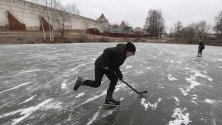 Деца играят на хокей върху замръзнало езеро край едноименния манастир в Борисоглебский, Русия. Зимата е мека и без сняг дори в тези северни части.