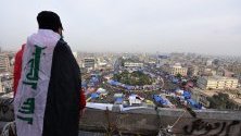 Демонстратор се е качил на покрива на изоставена сграда близо до площад "Ал Тахрир" в Багдад, Ирак, откъдето наблюдава палатков лагер на протестиращи.