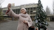 Бивша жителка на Припят си прави селфи пред коледна елха, сложена на централния площад в изоставения град до АЕЦ &quot;Чернобил&quot;. За първи път от 33 години в града бива поставена коледна елха.