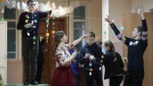 Ученици подготвят украса на новогодишна елха във физкултурен салон за празненство на Нова година в град Солигалич, Костромски регион, Русия.