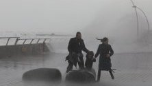 Семейство се опитва да се спаси от огромните вълни на пристанището в Тел Авив по време на буря.