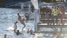 Участници в ежегодното зимно плуване скачат в езерото Лугано в Парадисо, Швейцария.