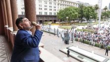 Марадона целува миниатюрно копие на Световната купа на ФИФА, която той спечели в Мексико през 1986 г. с аржентинския национален отбор, застанал на балкона на Каса Росада в Буенос Айрес по време на посещението му при президента на страната Алберто Фернандес.