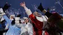 Мъже и жени, облечени като Дядо Мраз и Снежанка, участват в новогодишен парад в центъра на Минск, Беларус.