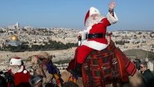 Група мъже и жени от целия свят, преоблечени като дядоколедовци, посещават Хълма на маслините над Ерусалим.