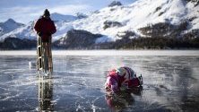 Хора се пързалят по езерото Зилзерзее, покрито с т.нар. &quot;черен лед&quot;, в Зилз, Швейцария. Черният лед е много опасен, тъй като е само лек замръзнал пласт на повърхността.