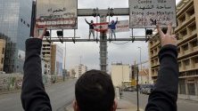 Протестиращи развяват ливанското знаме върху пътен знак по време на протести върху мост в Бейрут, Ливан.