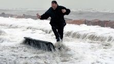 Вълни заливат човек на променадата в крайбрежното градче Алменара, Испания. Бурята Глория бушува по източното крайбрежие, взимайки най-малко три жертви.