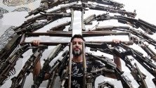 Мексиканският творец Алваро Куевас позира със скулптурата си, направена от оръжия, в Гуадалахара, Мексико. Куевас трансформира 12 тона оръжия в скулттури.