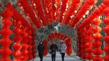 Хора се разхождат през тунел от червени фенери в Пекин преди настъпването на Китайската нова година на 25 януари.