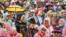 Около 250 Chrienser Boeoeggen с дървени маски и костюми участват в карнавална процесия в Кринс, Швейцария.