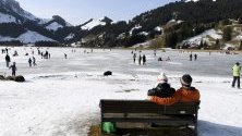 Хора се радват на слънчевото време, карайки кънки върху замръзналото езеро Шварцзее на 1045 м. над морското равнище в Източен Фрибург, Швейцария.