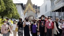 Туристи с маски из Големия дворец в Банкок, Тайланд, в опит да се предпазят от коронавируса.
