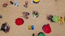 Хора се пекат на слънце на плажа Вермеля в Рио де Жанейро, Бразилия. Температурите там достигнаха 37 градуса.