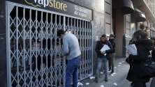 Търговец затваря магазина си докато синдикалисти го окуражават да се присъедини към общата стачка в Билбао, Испания.