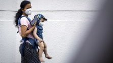 Жена и бебе със защитни маски срещу коронавируса по улиците на Банкок, Тайланд.