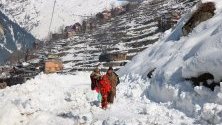 Местни жители вървят из преспи, паднали след лавина, Кашмир, Пакистан. Най-малко 90 души са загинали при различни инциденти с лавини в региона през последните дни.