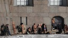 Руснаци си взимат слънчеви бани край крепостта &quot;Петър и Павел&quot; в центъра на Санкт Петербург, Русия. Температурите паднаха до около -6 градуса.