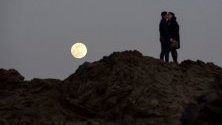 Двойка се целува на фона на Суперлуната в Менорка, Балеарските острови.