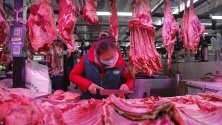 Продавач на месо със защитна маска срещу коронавируса на пазар в Пекин, Китай.
