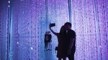 Посетители се снимат с интерактивна дигитална инсталация част от изложбата &quot;Бъдещ свят - изкуството се среща с науката&quot; в ArtScience музея в Сингапур.