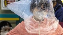Жена от Гуанджоу, Китай, носи защитна маска срещу коронавируса и се е защитила допълнително с найлонова торба върху себе си.