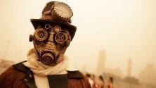 Участник в карнавал в Тенерифе, Канарските острови, който се провежда въпреки гъстите облаци от прах и пясък, донесени от Сахара.