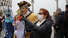 Туристи в защитни маски срещу коронавируса се снимат на площад &quot;Сан Марко&quot; във Венеция, Италия.