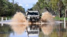 Кола минава през наводнена улица в Сейнт Джордж, Куийнсленд, Австралия, след излизането на река Балоун от коритото й с 12 метра заради проливни дъждове.