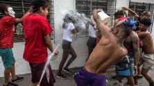 Младежи хвърлят кофи с вода по минувачи по време на карнавала в Нуево Сирко, Каракас, Венецуела.
