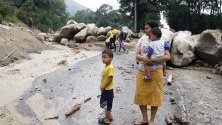 Местни жители наблюдават свлачище в Пиедекуеста, Колумбия. Проливните дъждове засегнаха обширни райони на Андите и причиниха жертви сред населението.