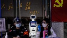 Робот помага на служителите при проверка на температурата на посетители в правителствена сграда в Гуанджоу, Китай.