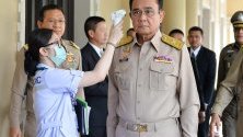 Лекари проверяват температурата на премиера на Тайланд за коронавирус.