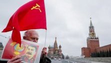 Комунист в Русия държи портрет на Сталин по време на честване на 67 години от смъртта му край Кремъл, Москва.