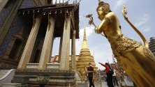 Туристи в предпазни маски срещу коронавируса посещават храма на Смарагдовия Буда в Банкок, Тайланд. Страната отчита спад на туристите с 6 милиона до най-ниското ниво от четири години.