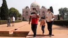 Туристи с предпазни маски срещу коронавируса в гробницата на Хумаюн в Делхи, Индия.