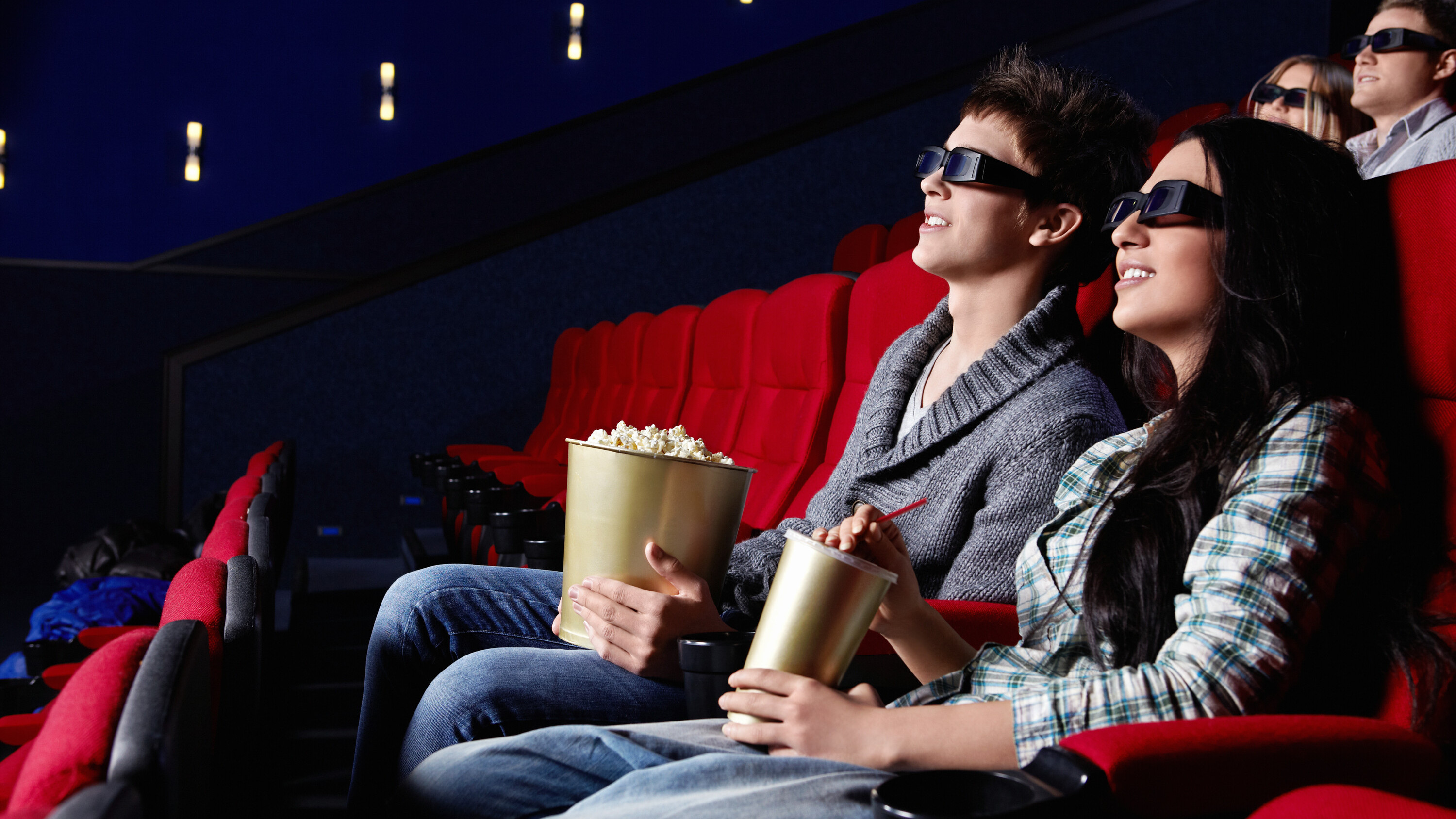 New films in cinema. Люди сидят в кинотеатре. Пара в кинотеатре. Фотосессия в кинотеатре. Парень с девушкой в кинотеатре.